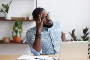 man in glasses in front of his computer