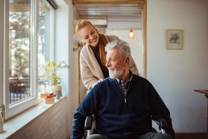 female pushing a man in a wheelchair